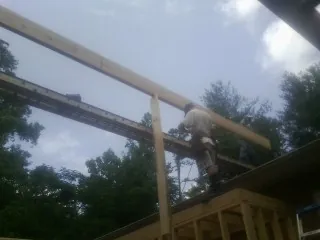 Carpenter setting a ridge beam over a new addition frame — Ice Dam Removal by Roofing Brothers in Gooding